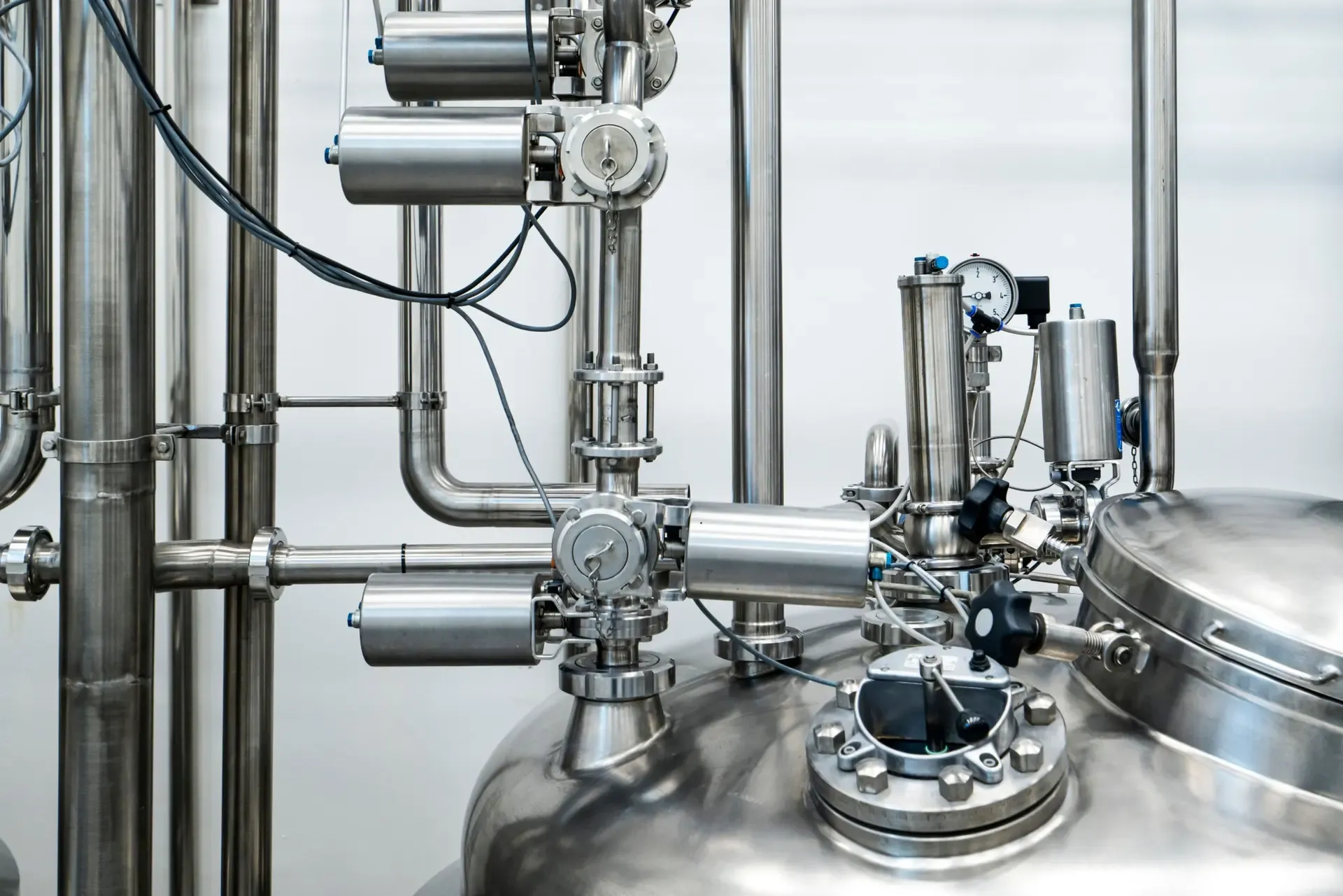 Stainless steel process vessel with pneumatic valves, pipework and a pressure gauge