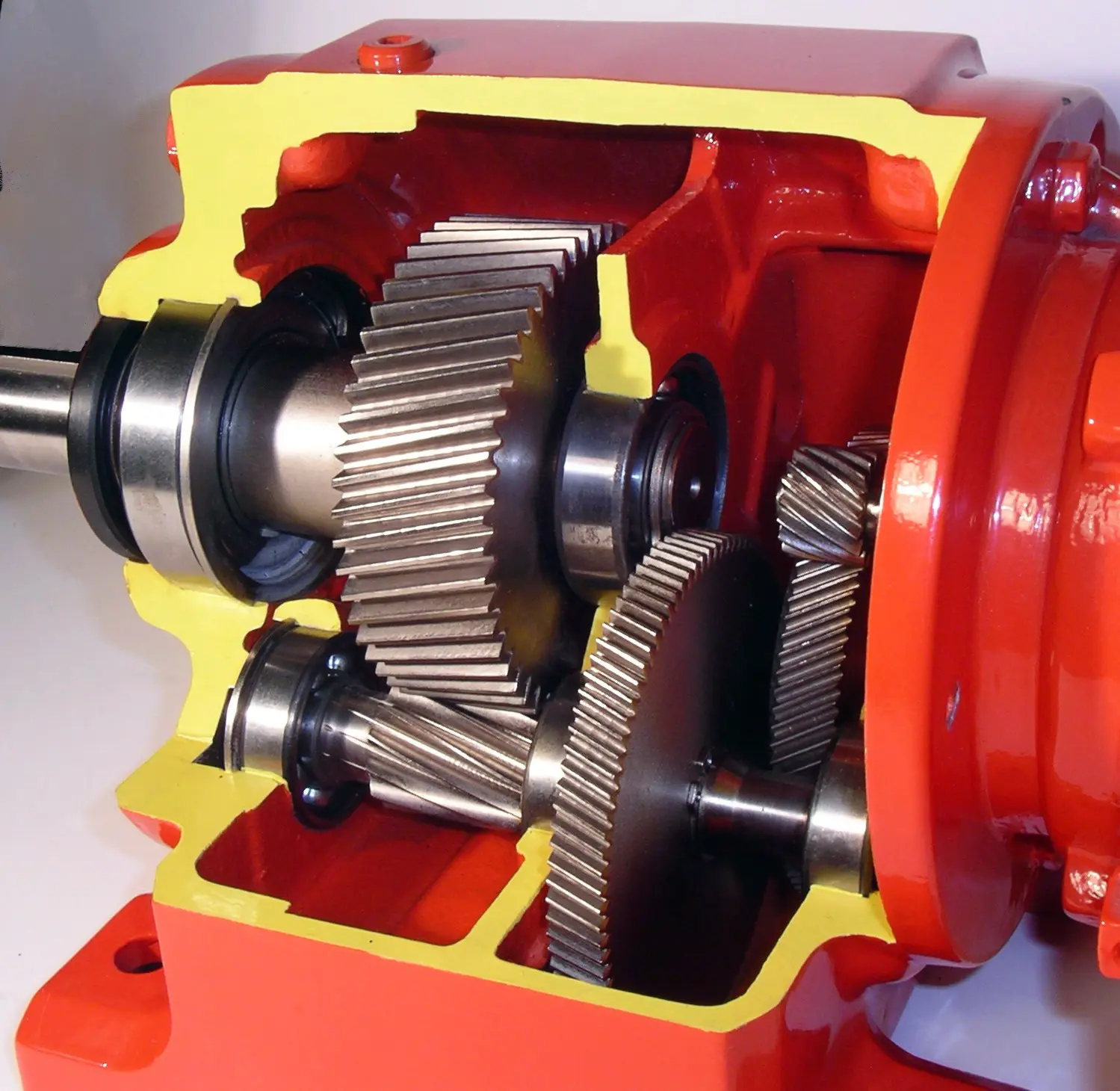 Helical in-line gear reducer, a cutaway housing showing three stages of helical gears, shafts and bearings