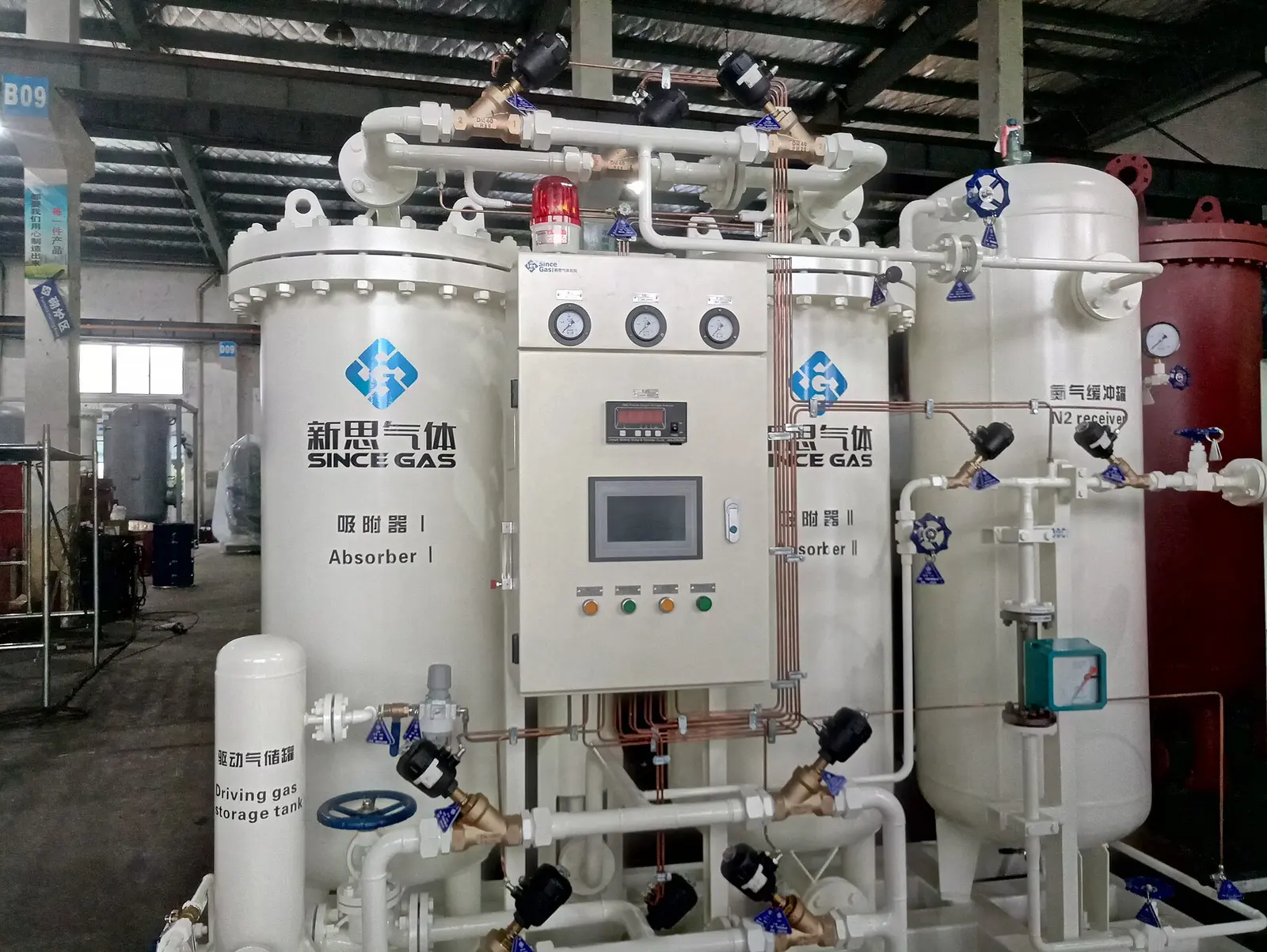 PSA nitrogen generator with two white adsorber towers, a central control panel with gauges and touchscreen, a nitrogen receiver tank and pneumatic valves, in a factory workshop