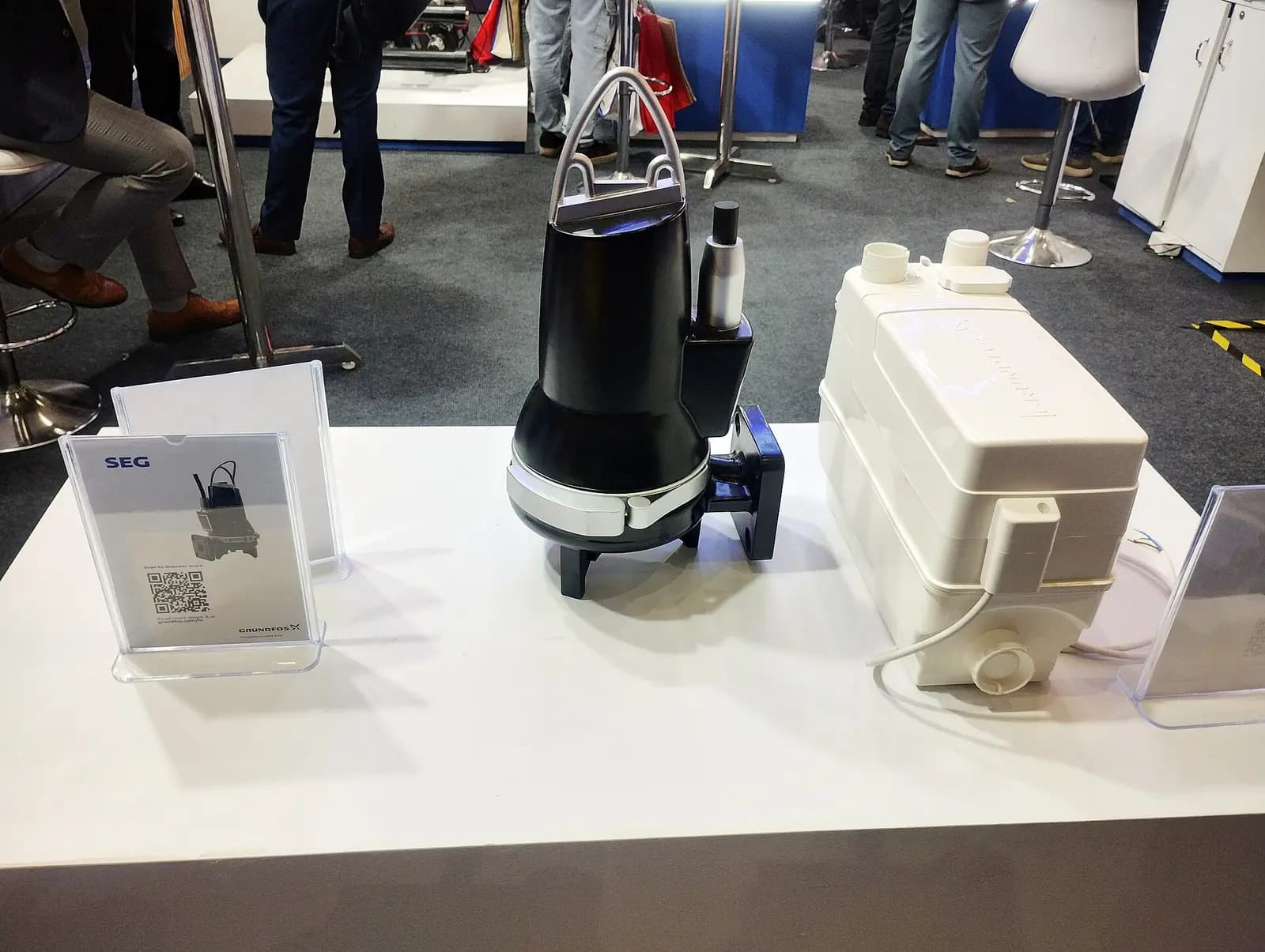 Submersible sewage pump, a black cast-iron sealed motor-pump unit with lifting handle and discharge flange on a display table